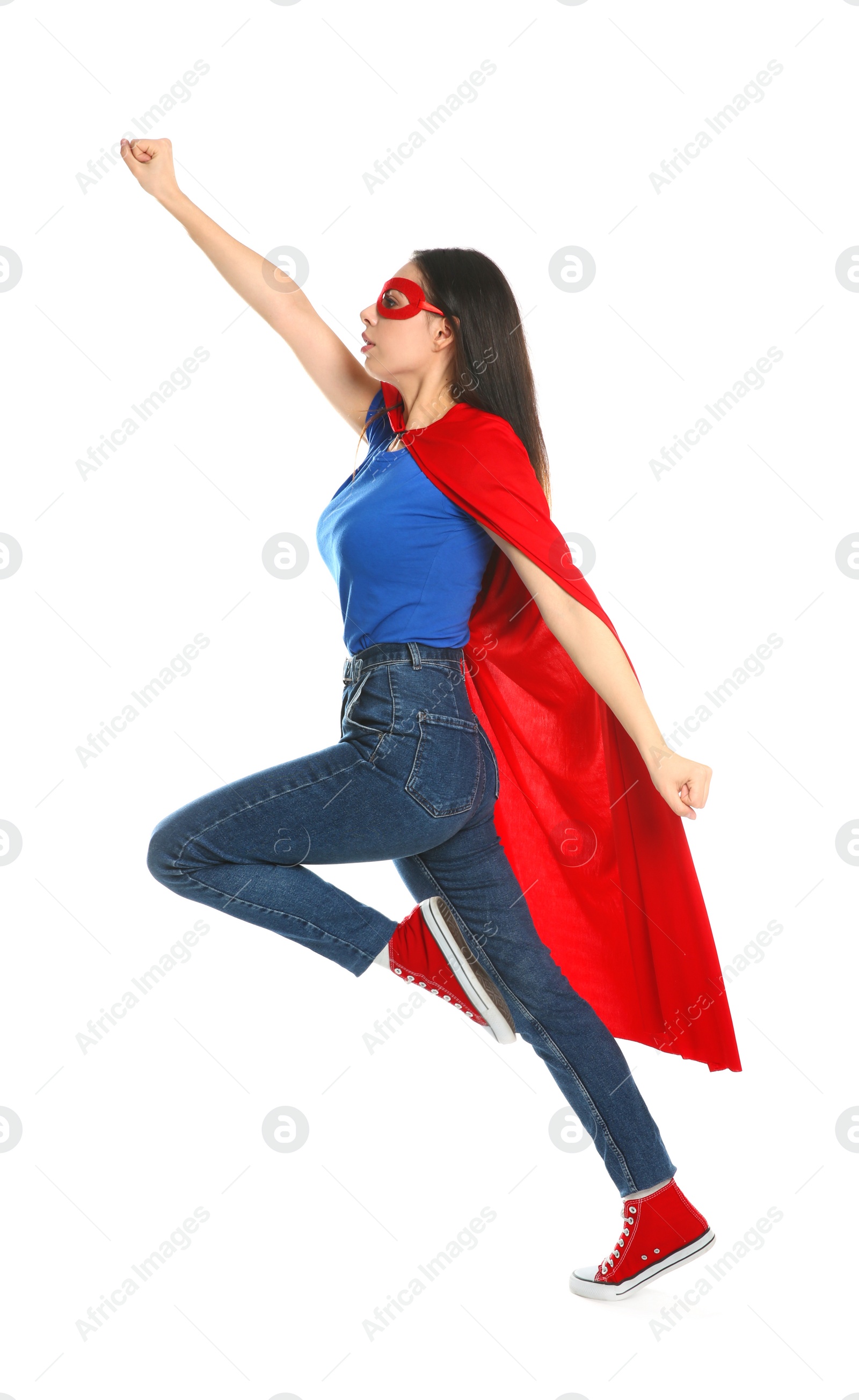 Photo of Confident young woman wearing superhero cape and mask on white background