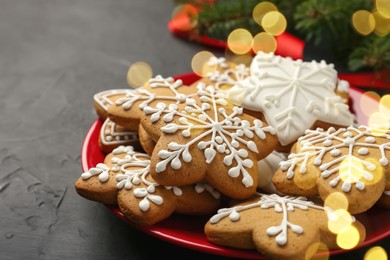 Photo of Tasty Christmas cookies with icing on black table, closeup