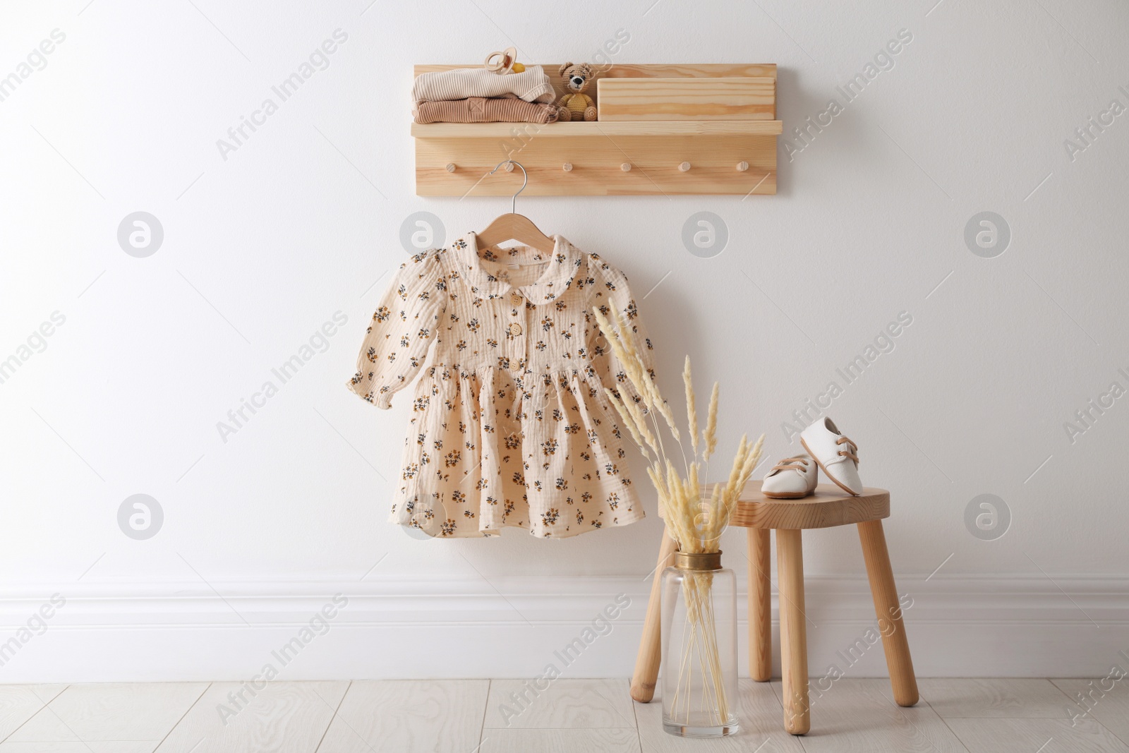 Photo of Cute children's clothes and shoes in room