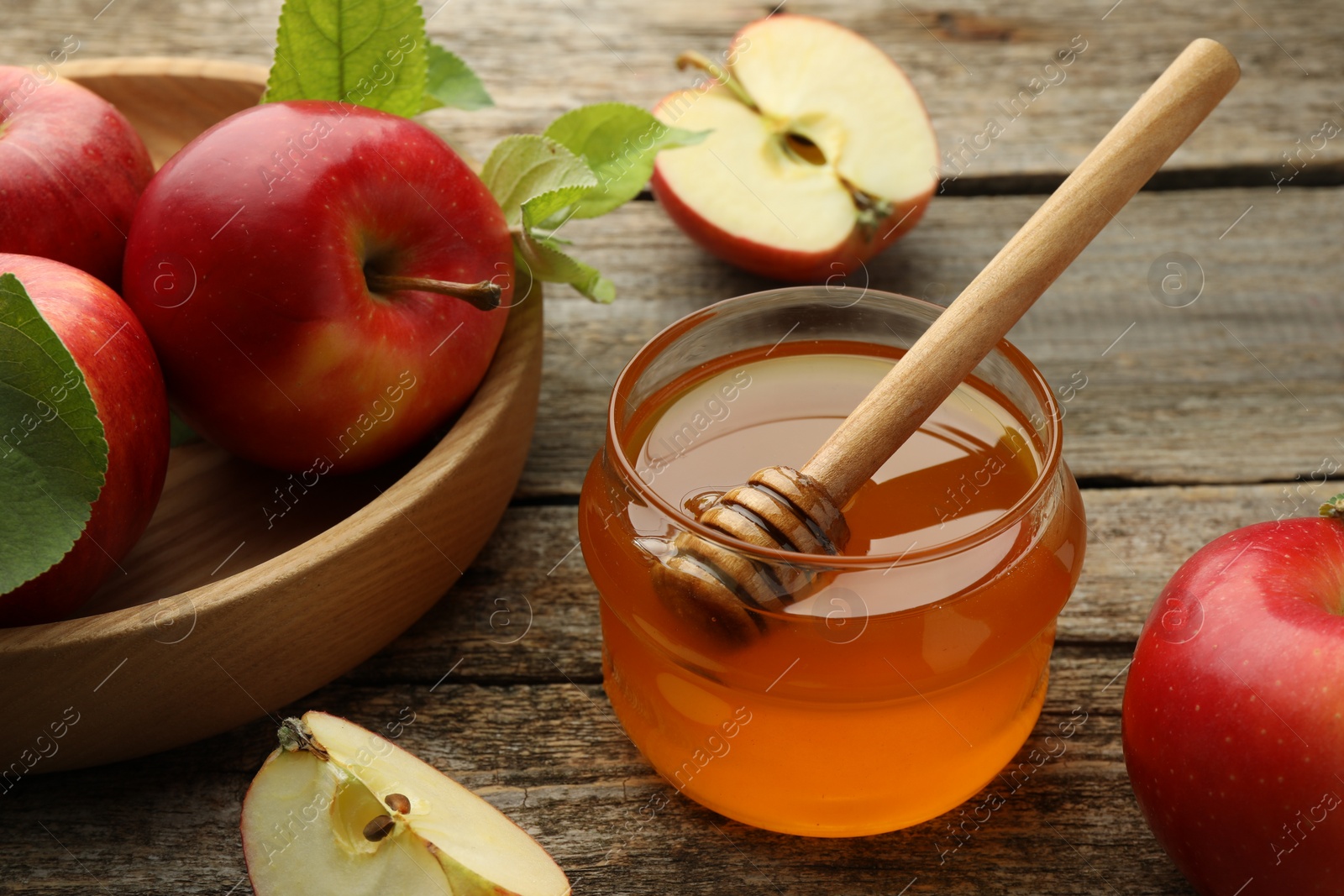 Photo of Sweet honey and fresh apples on wooden table, closeup