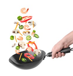 Image of Man tossing ingredients in wok on white background, closeup