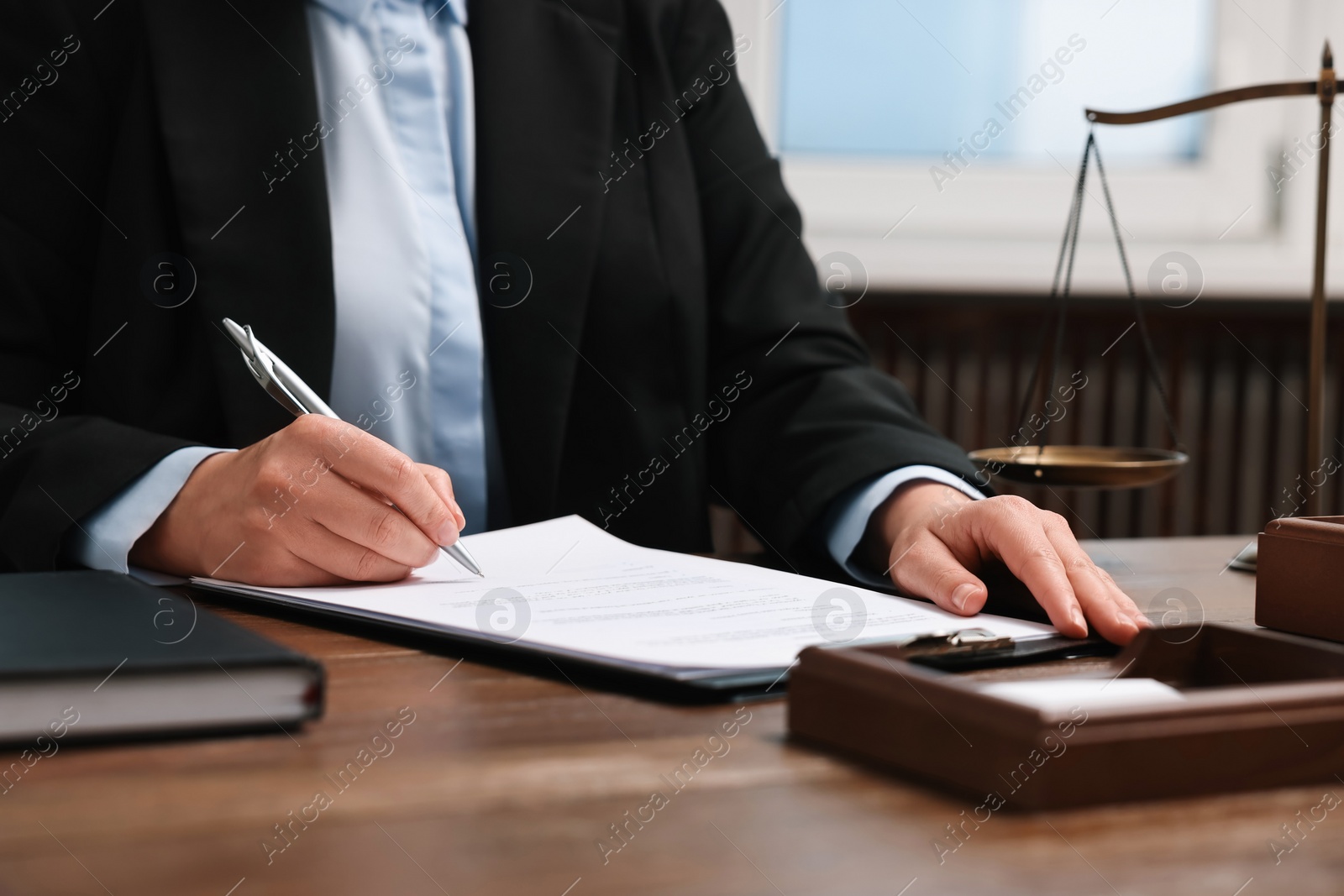 Photo of Lawyer working at wooden table in office, closeup