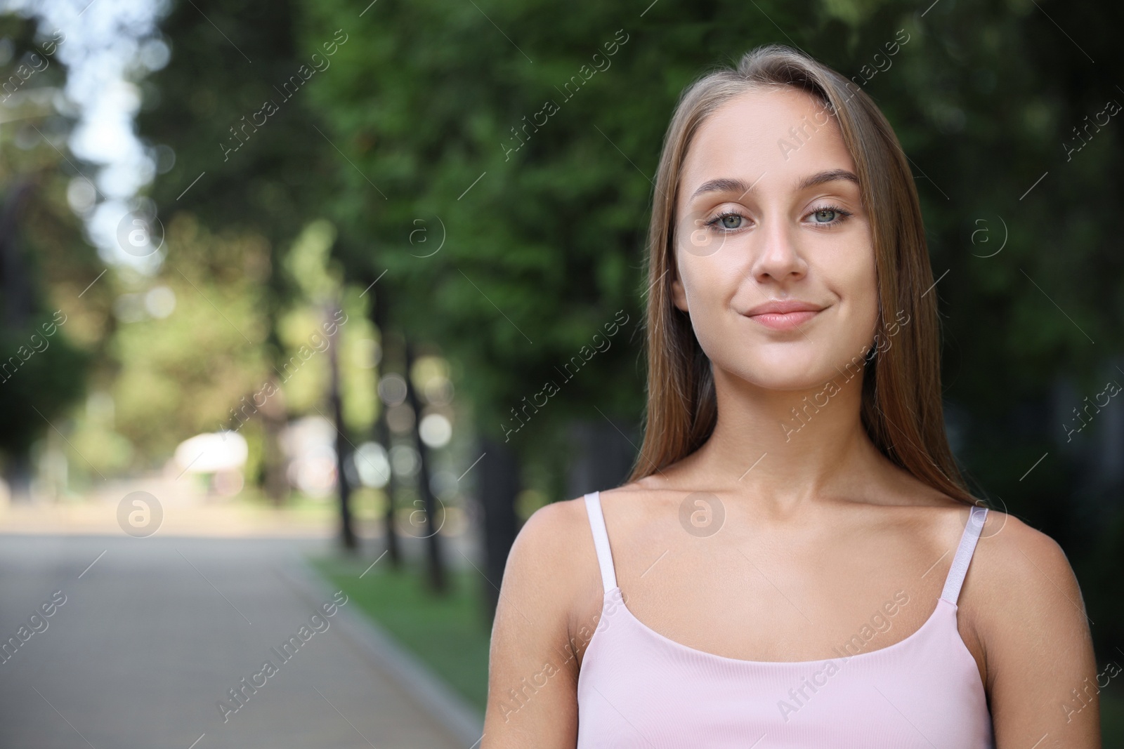 Photo of Portrait of beautiful young woman in park, space for text