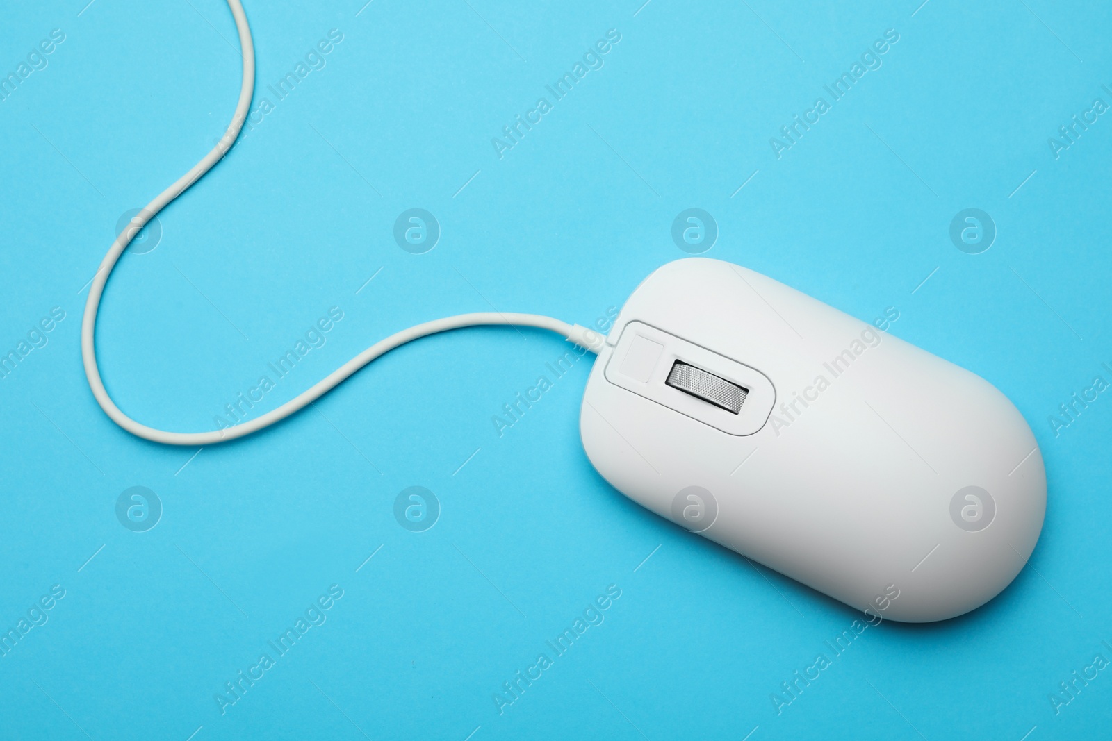 Photo of Wired computer mouse on light blue background, top view