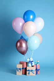 Photo of Many gift boxes and balloons on light blue background