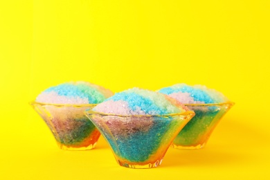 Photo of Rainbow shaving ice in glass dessert bowls on yellow background