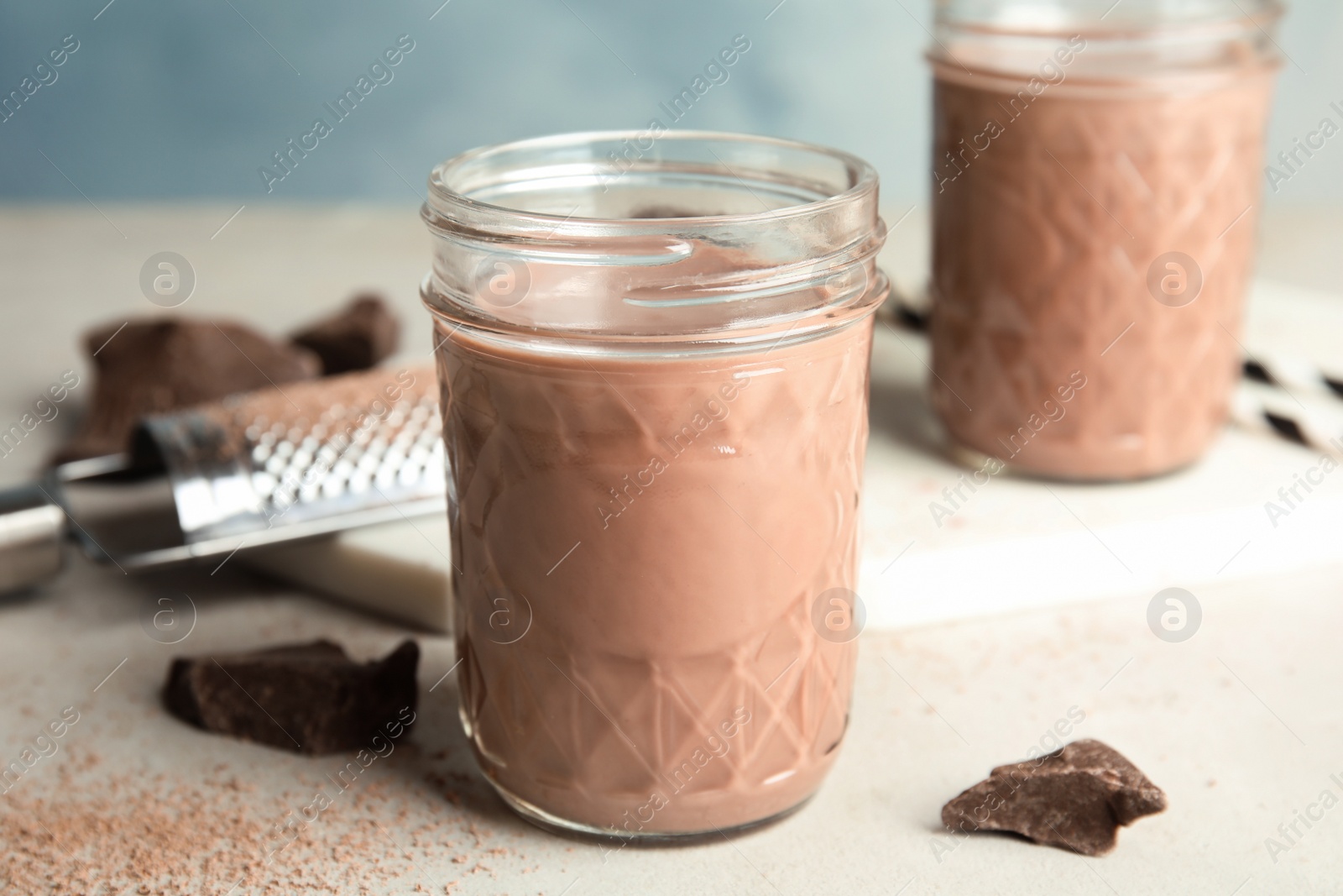 Photo of Jar with tasty chocolate milk on table. Dairy drink