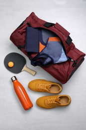 Photo of Sports bag and table tennis equipment on white  background, flat lay