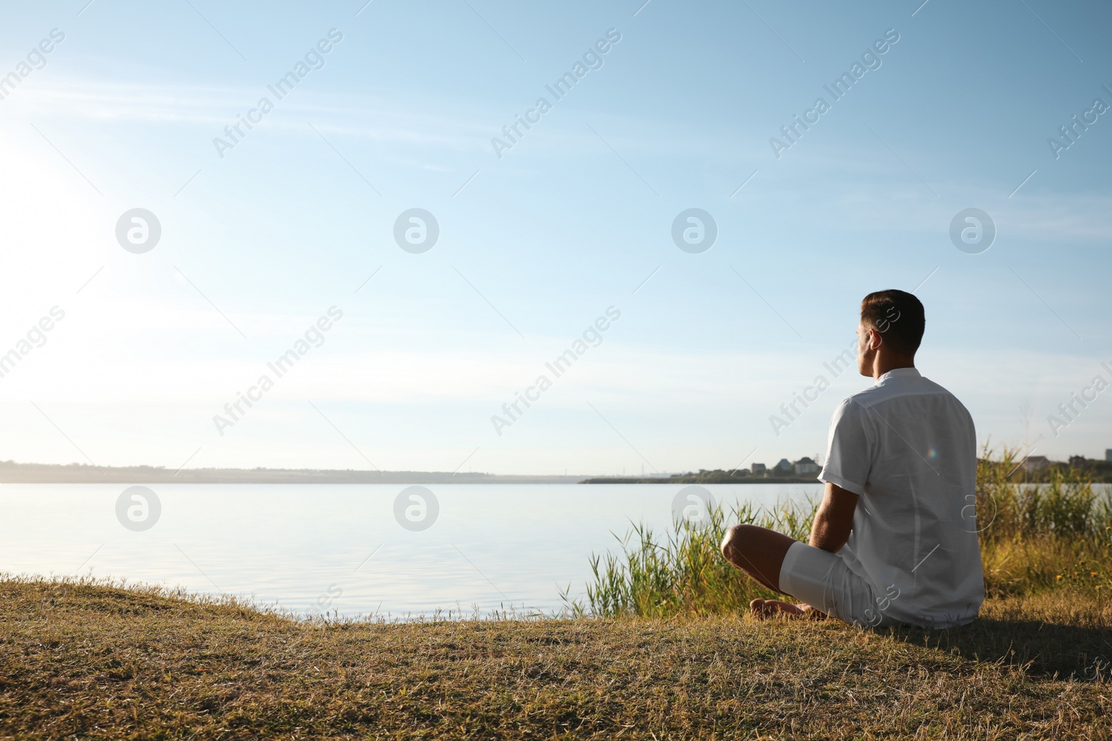 Photo of Man near river at sunset, space for text. Nature healing power