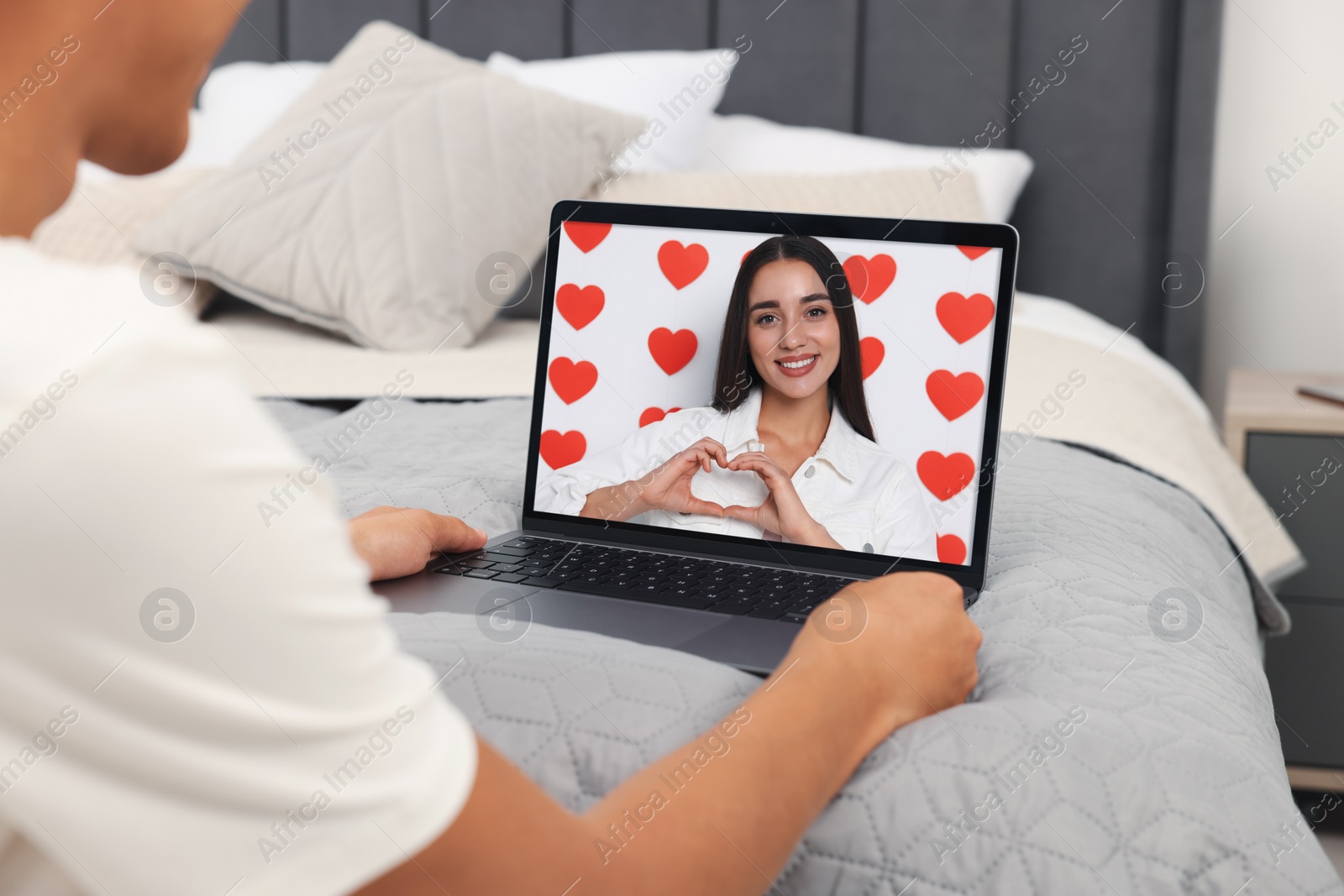 Image of Long distance love. Man having video chat with his girlfriend via laptop at home, closeup