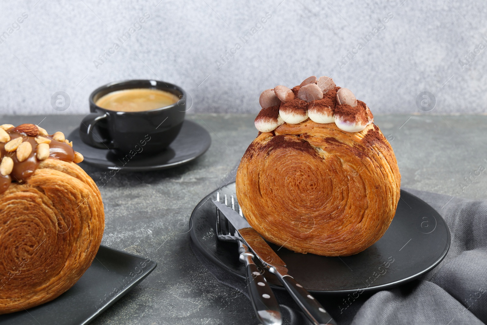 Photo of Crunchy round croissants served on grey table. Tasty puff pastry