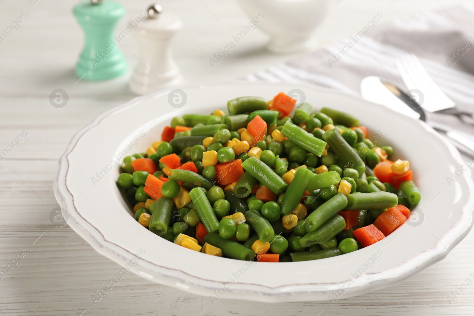 Photo of Mix of fresh vegetables served on white wooden table