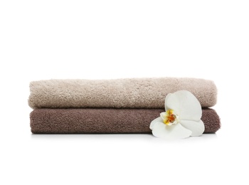 Clean folded towels with flower on white background