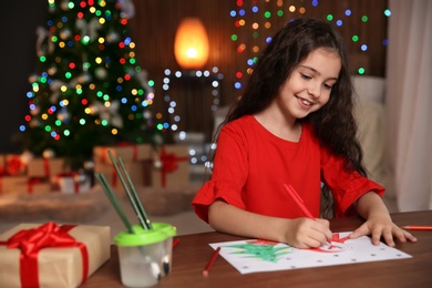 Photo of Little child drawing picture at home. Christmas celebration