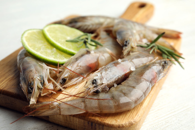 Photo of Fresh raw shrimps on white wooden table, closeup