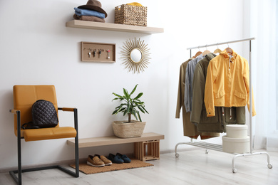 Photo of Hallway interior with stylish furniture, clothes and accessories
