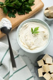 Photo of Delicious tofu cheese with parsley and spoon on white marble table, flat lay