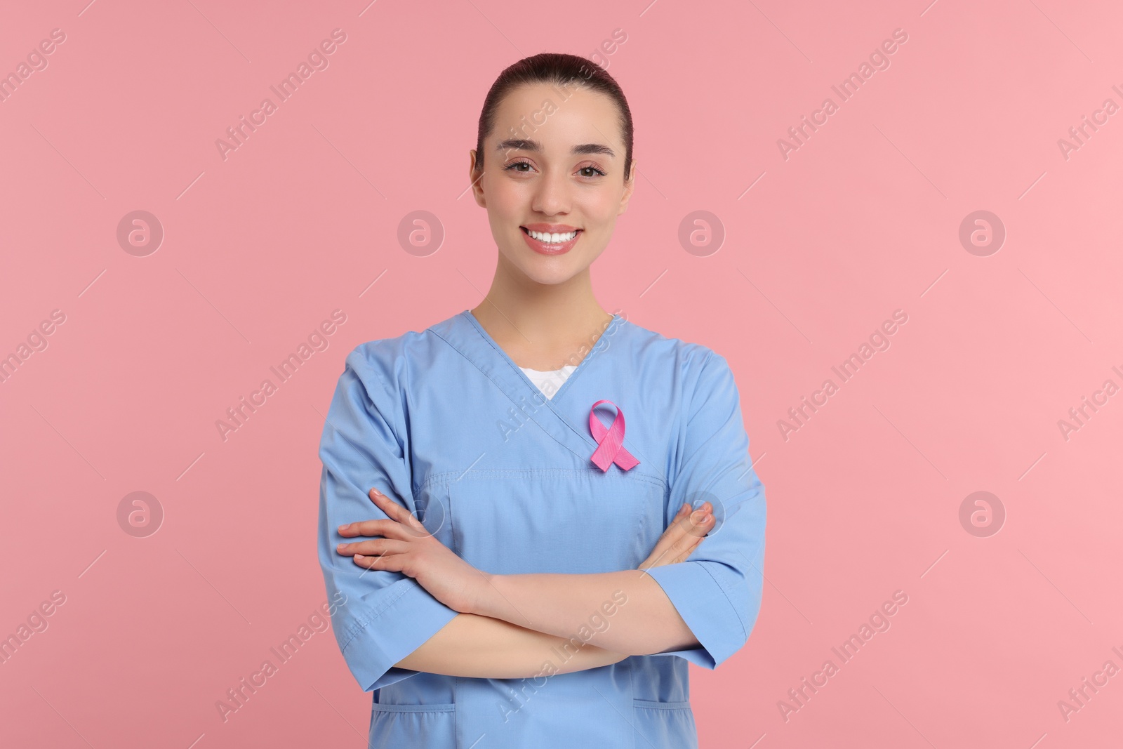 Photo of Mammologist with pink ribbon on color background. Breast cancer awareness