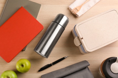 Photo of Flat lay composition with thermos and lunch box on wooden background