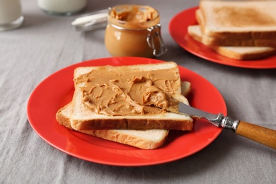 Photo of Plate with toasts and peanut butter on table