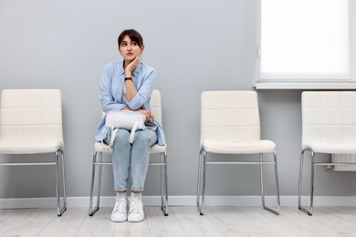 Woman sitting on chair and waiting for job interview indoors