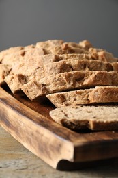 Photo of Freshly baked cut sourdough bread on wooden table, closeup