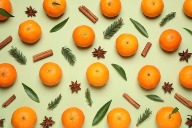 Photo of Christmas composition with tangerines on light green background, flat lay