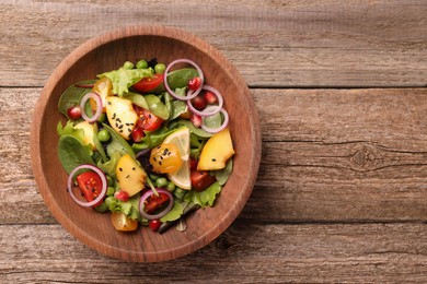 Photo of Delicious salad with peach, green peas and vegetables in bowl on wooden table, top view. Space for text