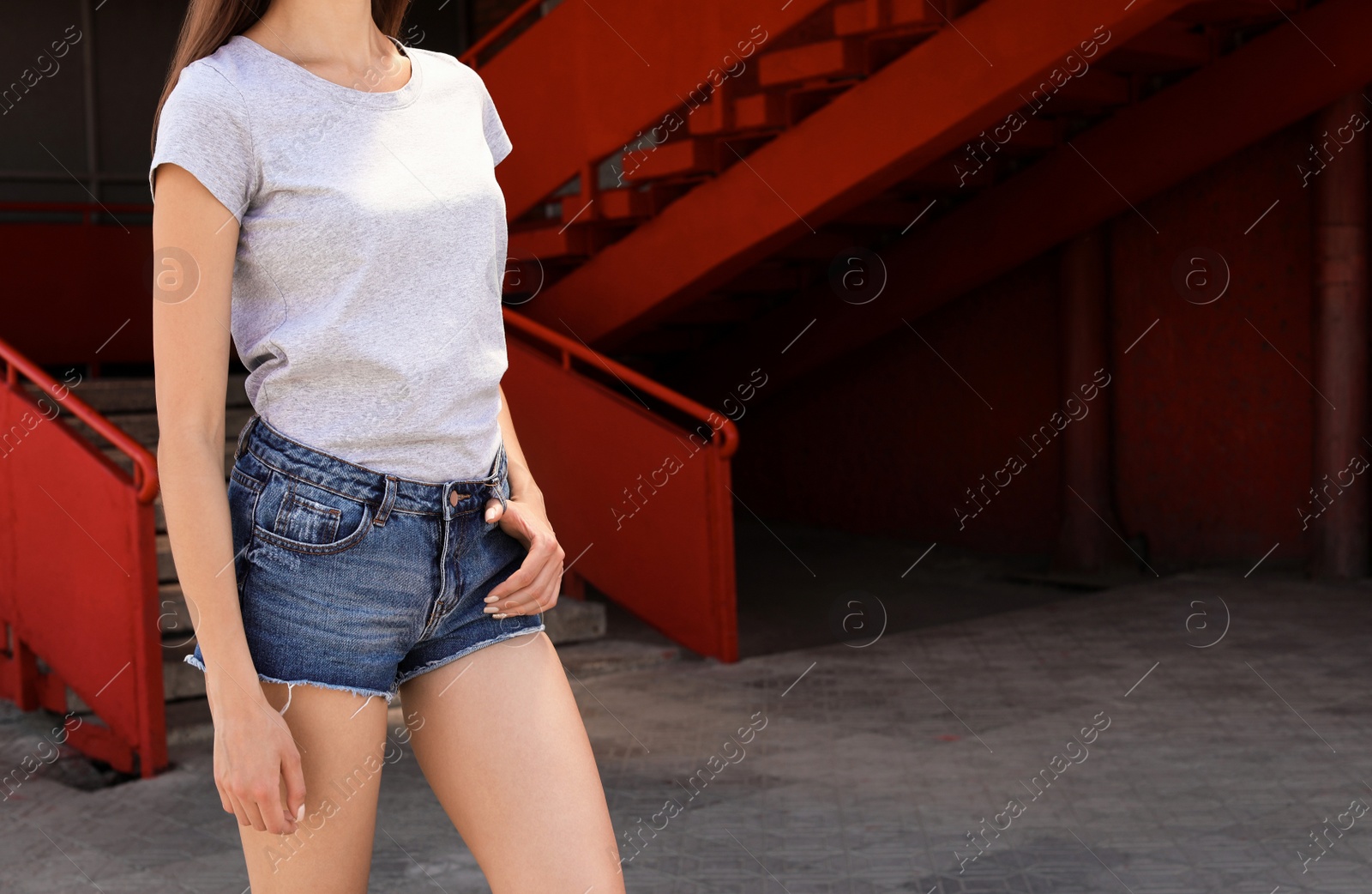 Photo of Young woman wearing gray t-shirt on street. Urban style