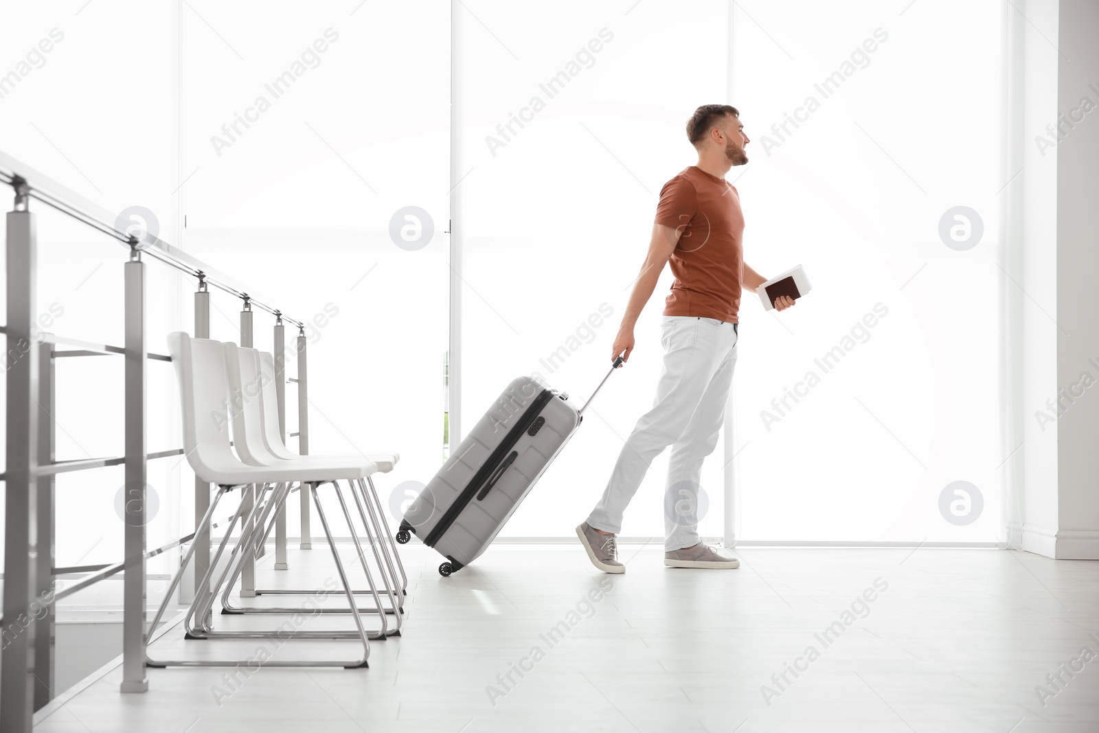 Photo of Young man with suitcase in airport