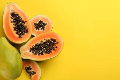 Photo of Fresh ripe papaya fruits on yellow background, flat lay. Space for text