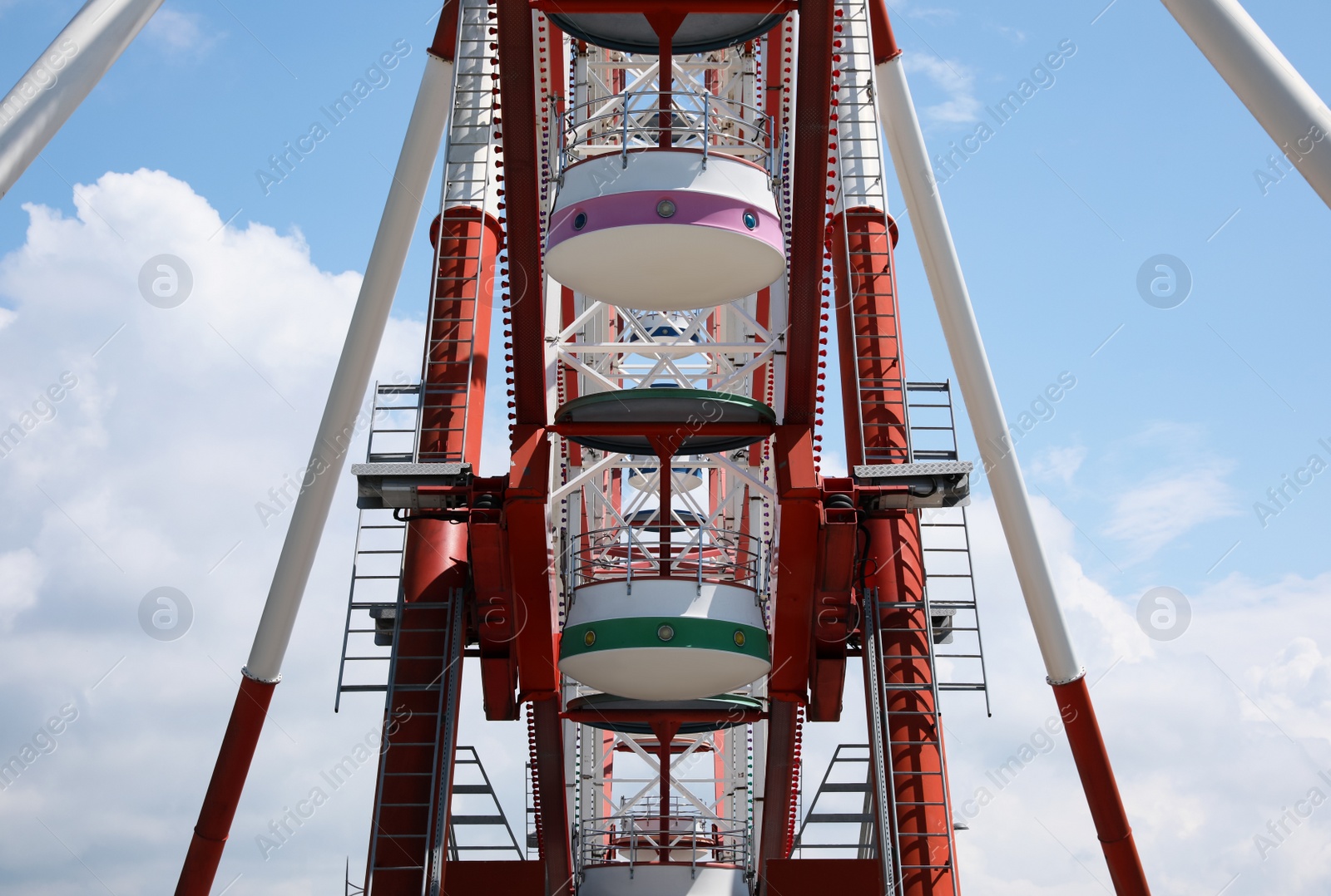 Photo of Beautiful large Ferris wheel against cloudy sky, closeup