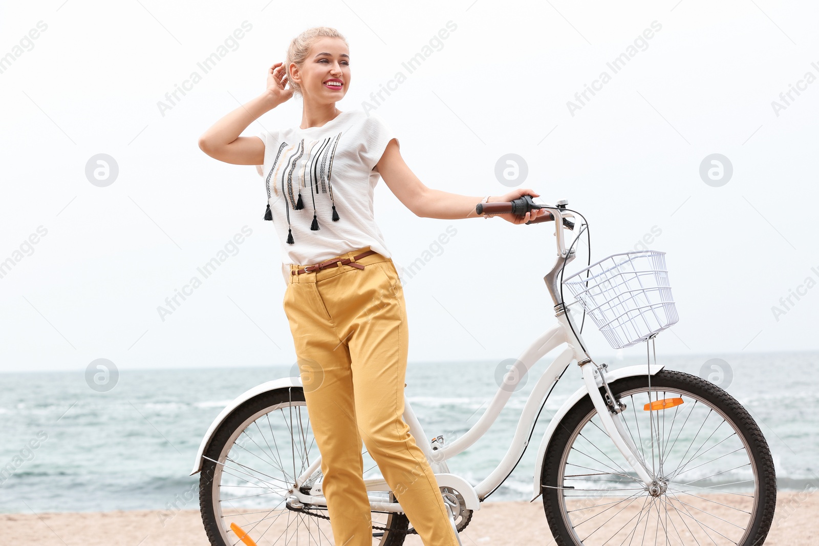 Photo of Beautiful woman in casual outfit with bicycle on sea coast