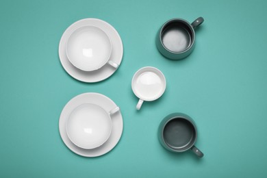 Photo of Different cups on turquoise background, flat lay