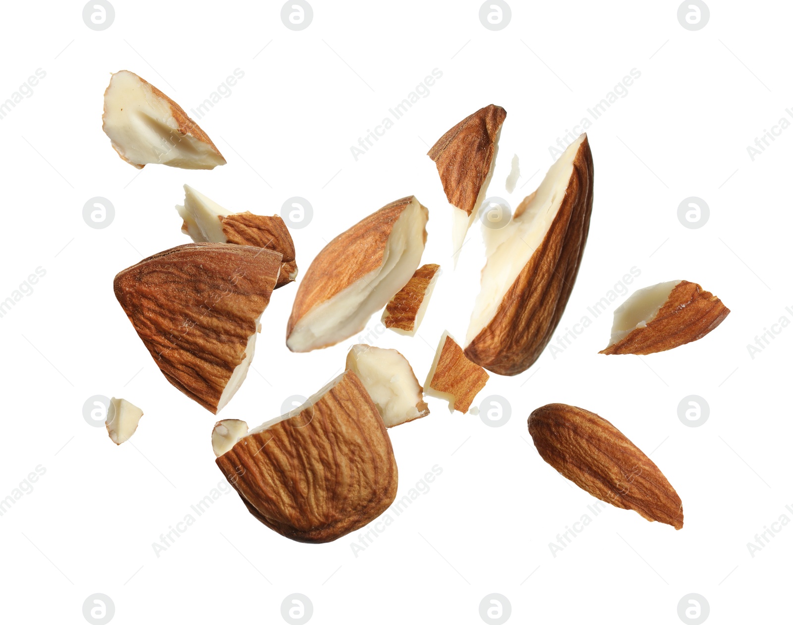 Image of Pieces of tasty almonds falling on white background