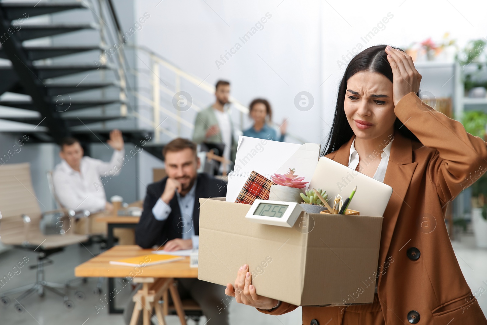 Photo of Upset dismissed young woman carrying box with stuff in office, space for text