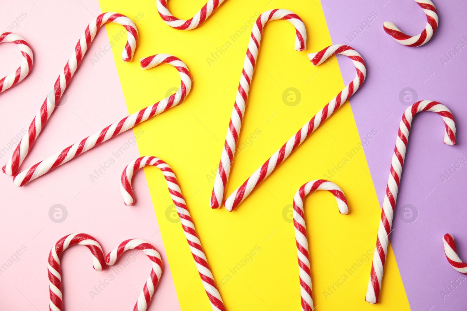 Photo of Flat lay composition with candy canes on color background