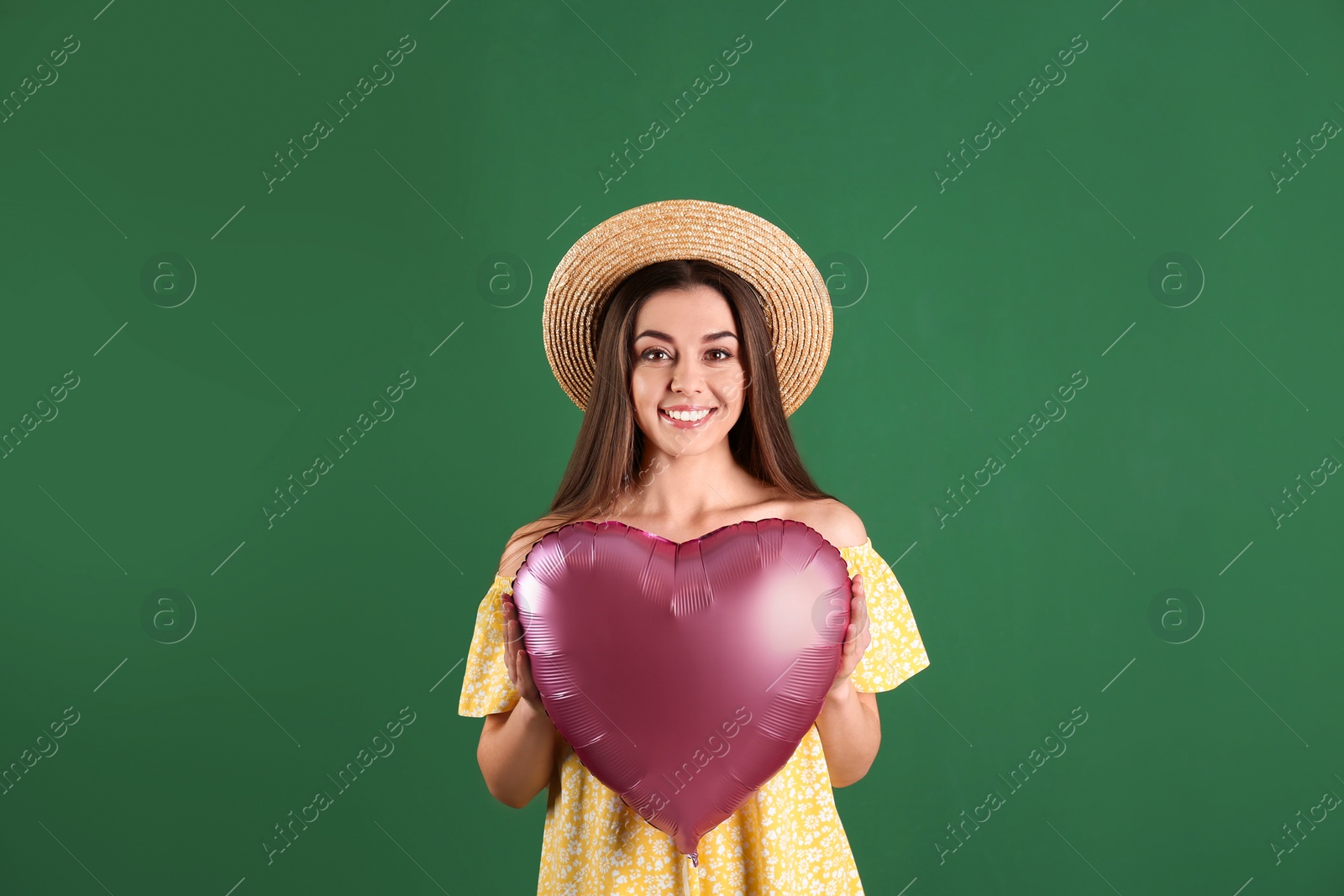 Photo of Portrait of young woman with heart shaped balloon on color background