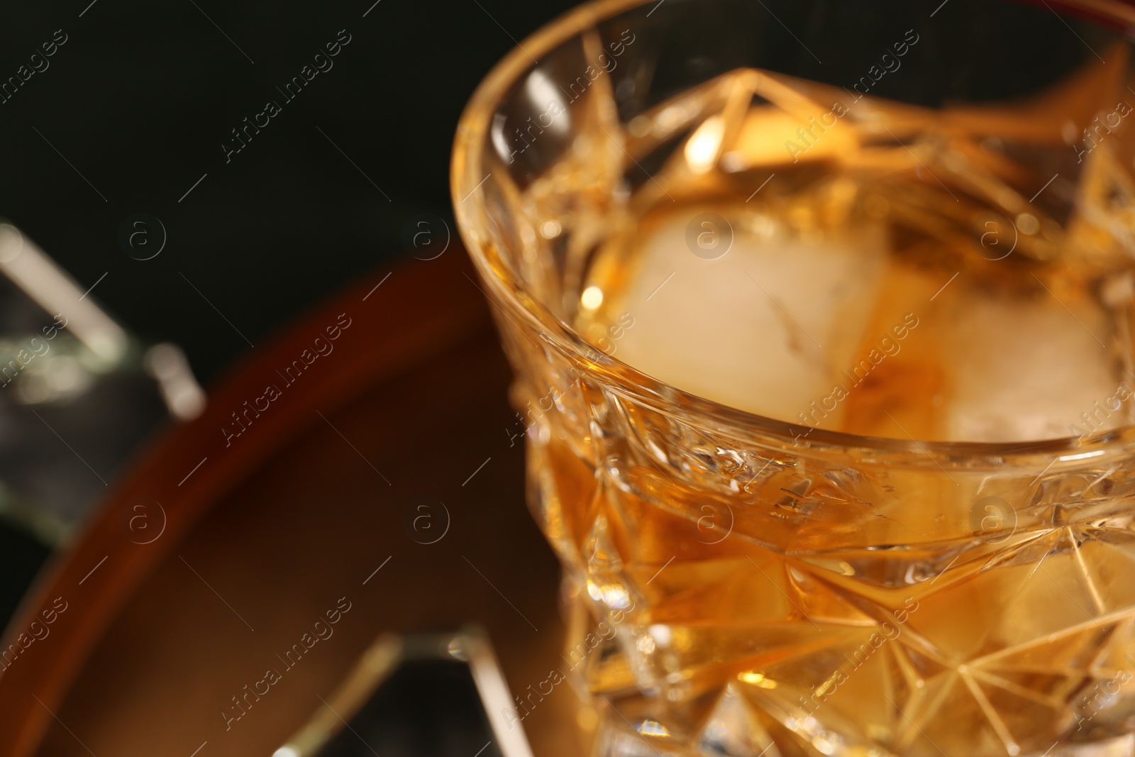 Photo of Glass of alcohol drink on golden tray, closeup. Space for text