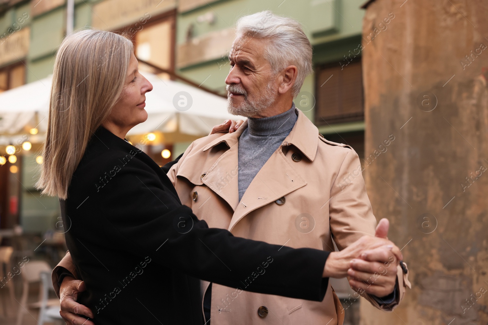 Photo of Affectionate senior couple dancing together on city street