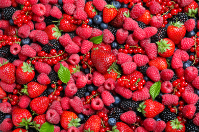 Photo of Mix of different ripe tasty berries as background, top view