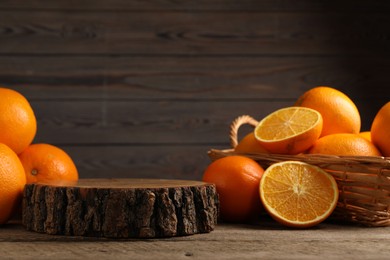 Photo of Fresh oranges on wooden table, space for text