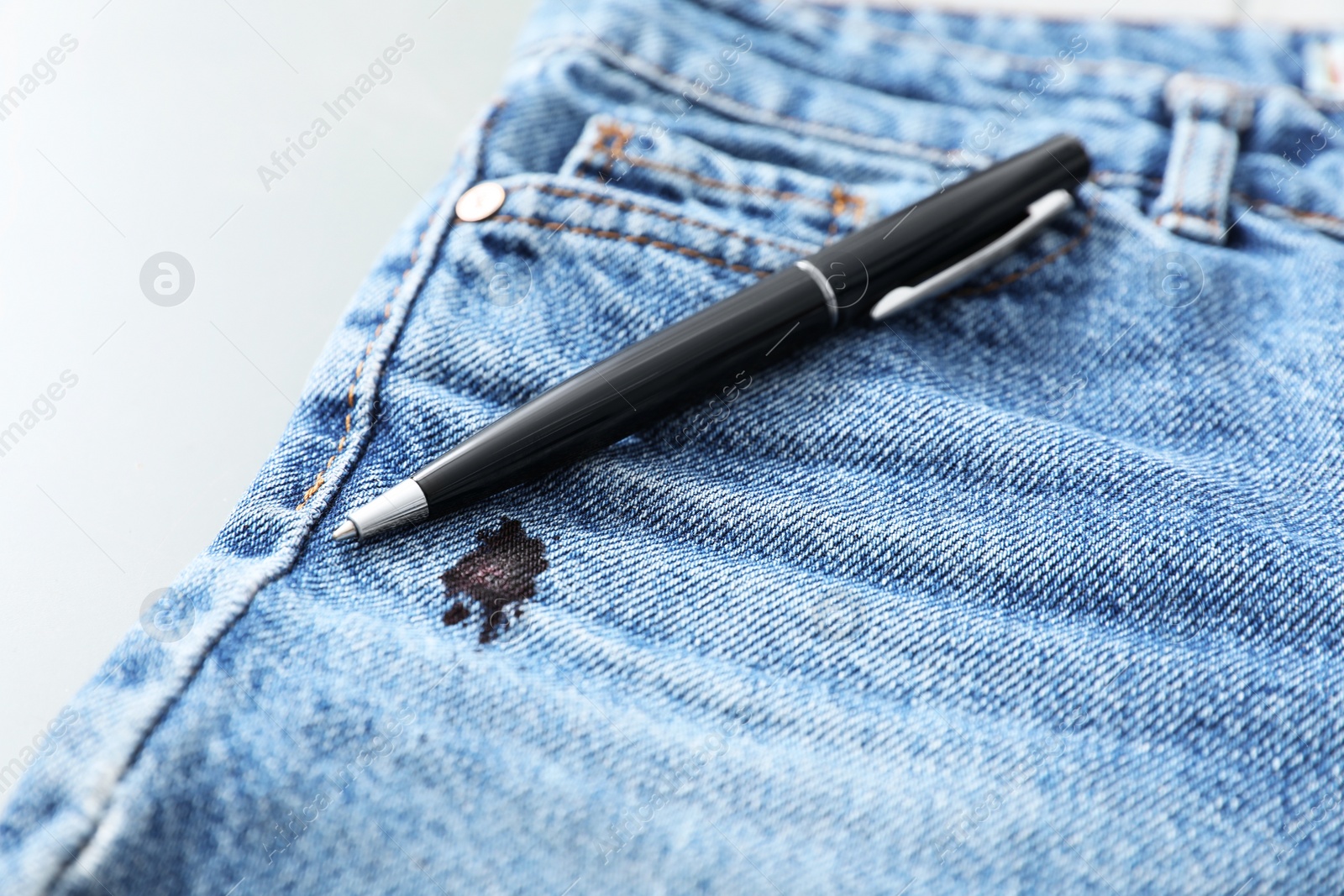 Photo of Pen and stain of black ink on jeans, closeup