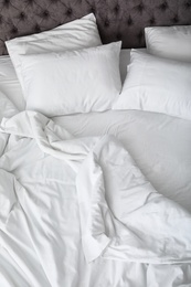 Soft white pillows on comfortable bed, closeup