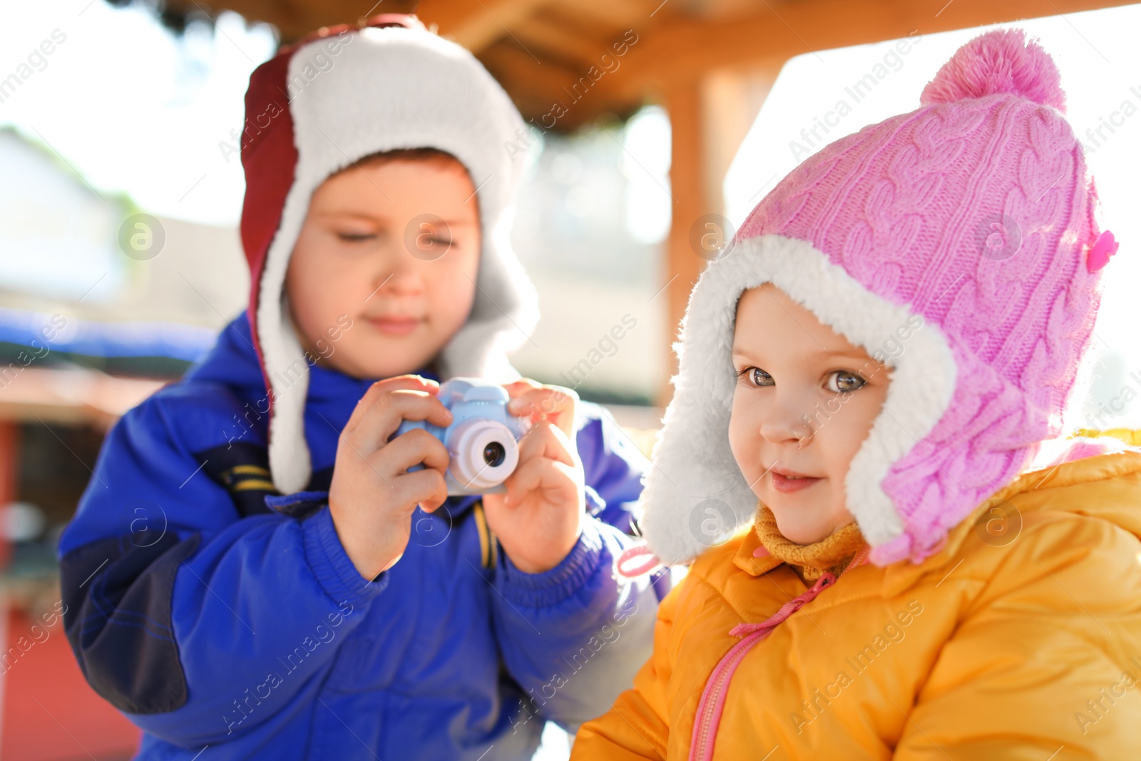 Photo of Little boy taking picture of girl outdoors. Future photographer