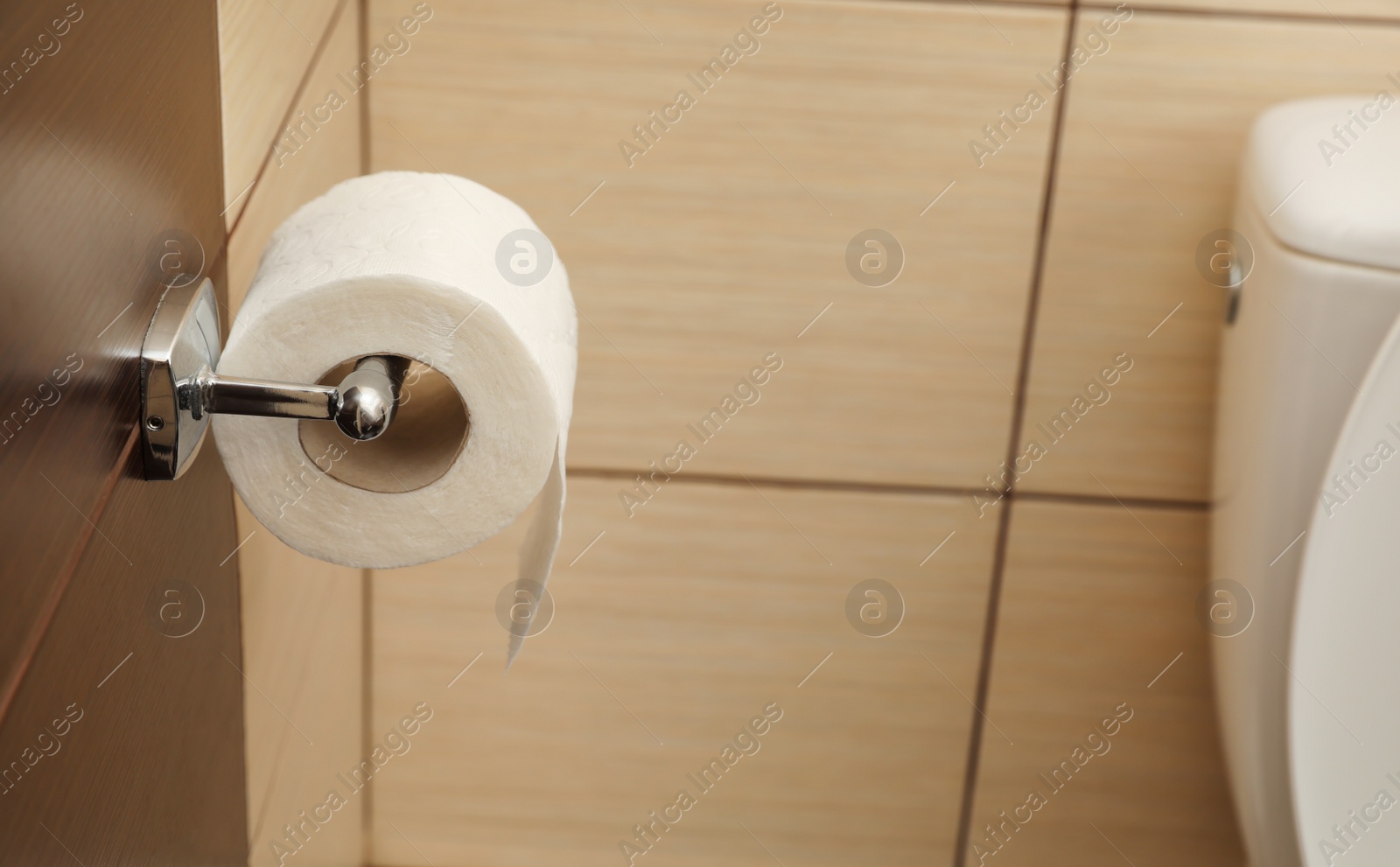 Photo of Holder with soft toilet paper roll in bathroom. Space for text