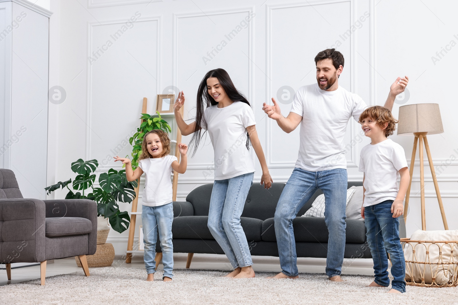 Photo of Happy family dancing and having fun in living room