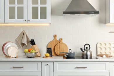 Photo of Countertop with stove, products and cooking utensils in kitchen