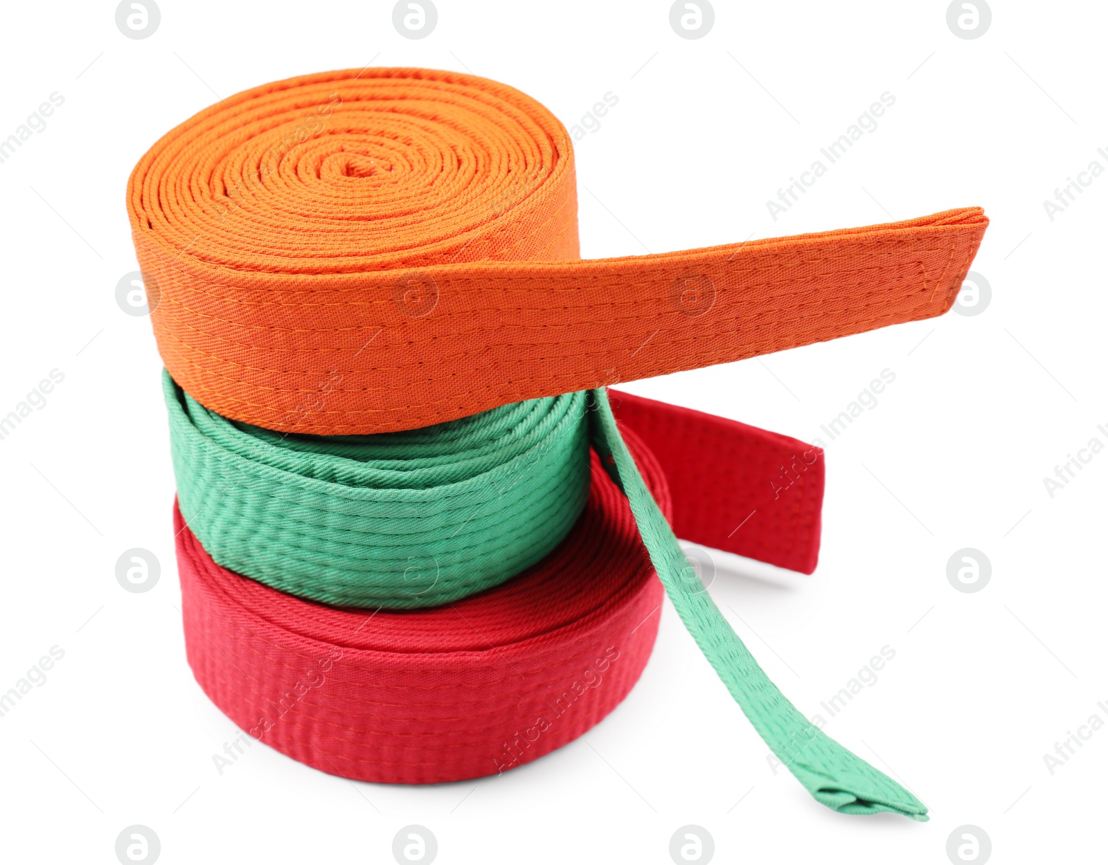 Photo of Stack of orange, green and red karate belts isolated on white