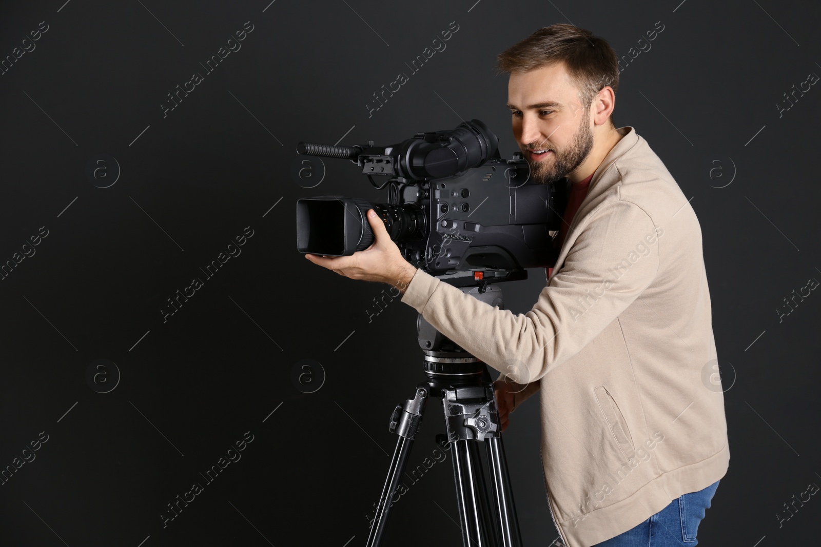 Photo of Operator with professional video camera on black background